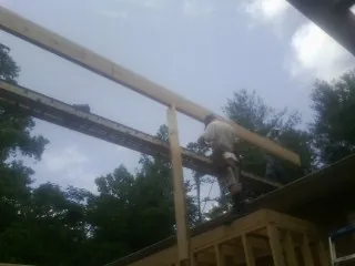 Carpenter setting a ridge beam over a new addition frame — Ice Dam Removal by Roofing Brothers in Rio Rancho