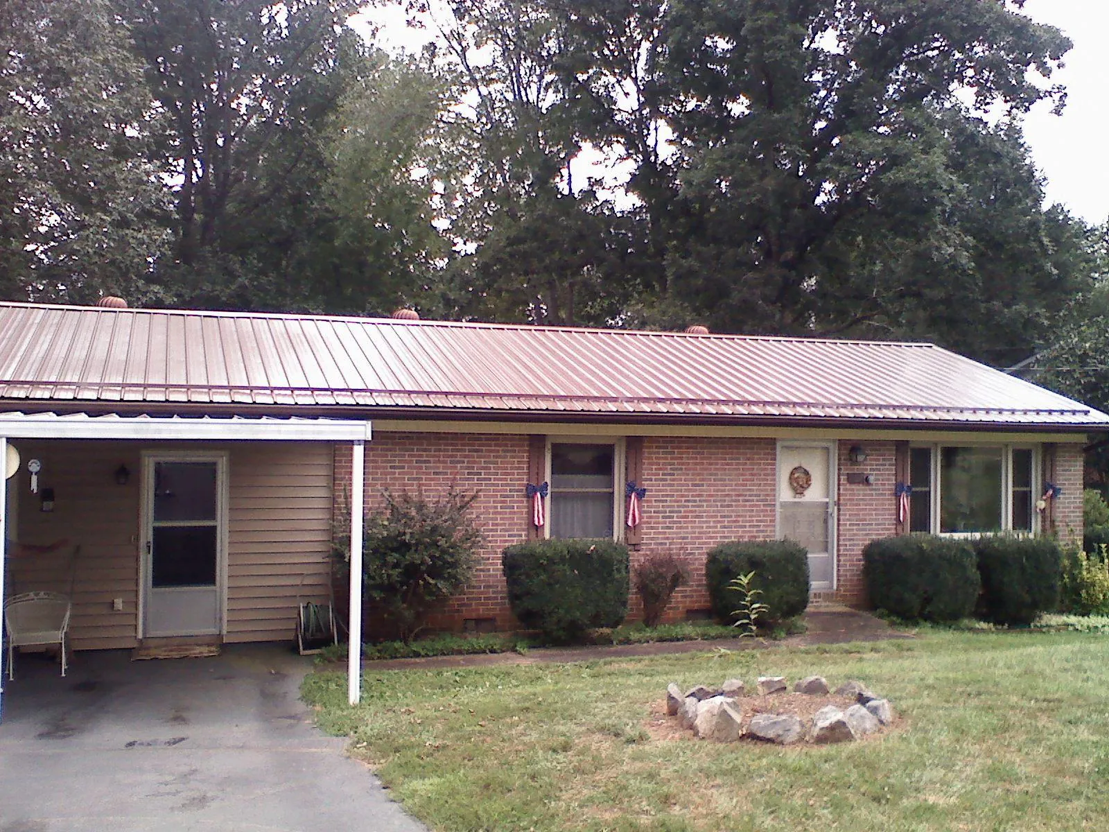 Bronze metal roof and carport on a brick ranch home — Roof Repair work by our crew in Rio Rancho